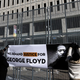 Jaylani Hussein (L), Executive Director of the Minnesota chapter of the Council on American-Islamic Relations (CAIR-MN) and a community activist, holds a banner during a press conference outside the US District Court in St. Paul, Minnesota, on January 20, 2022, for the jury selection of three former Minneapolis police officers charged with federal civil rights violations in George Floyd’s death.